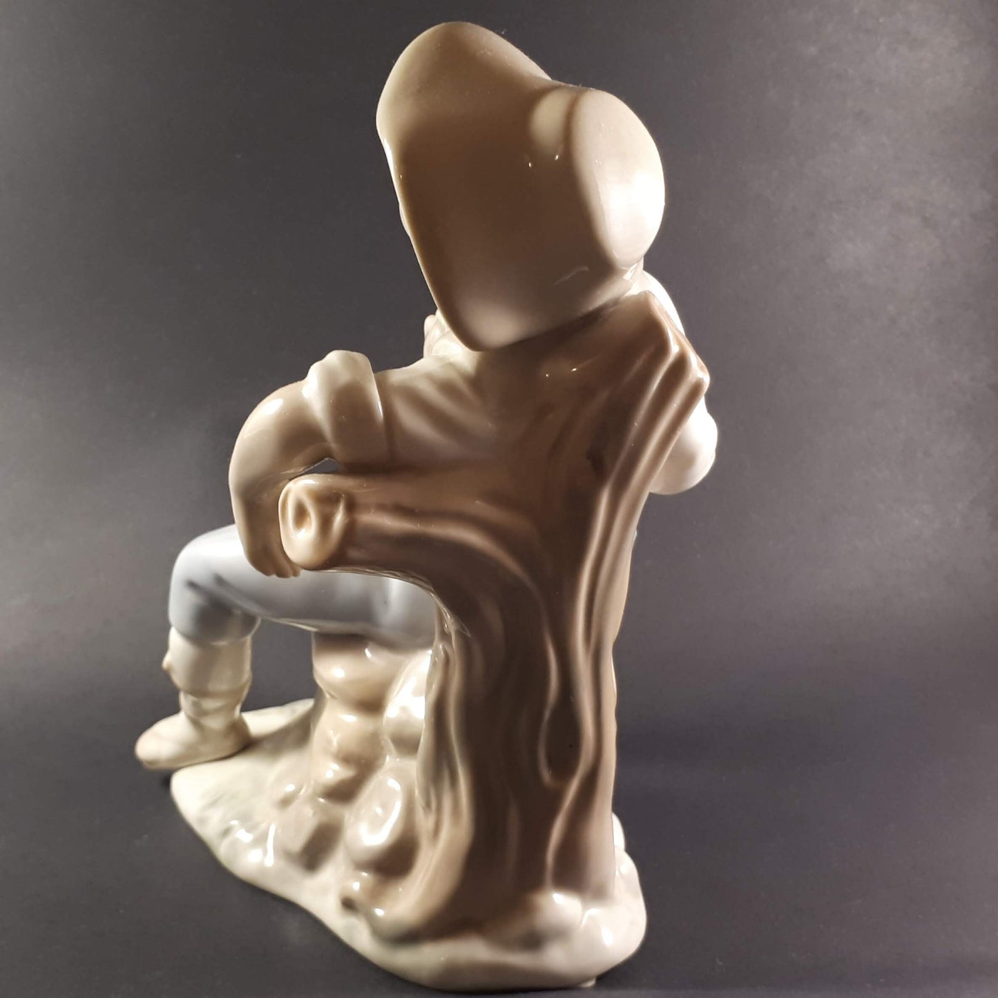 Tengra Spanish figurine boy sitting on beautiful shiny porcelain tree trunk