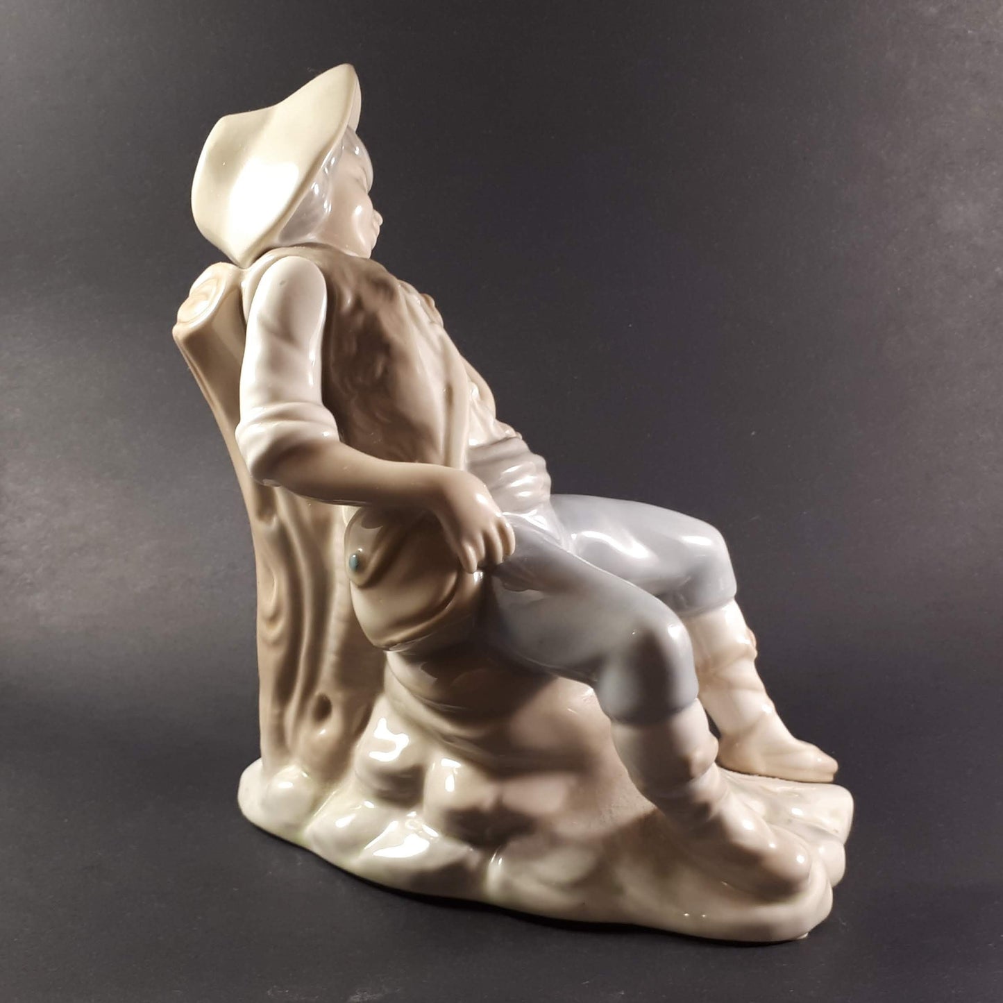 Tengra Spanish figurine boy sitting on beautiful shiny porcelain tree trunk