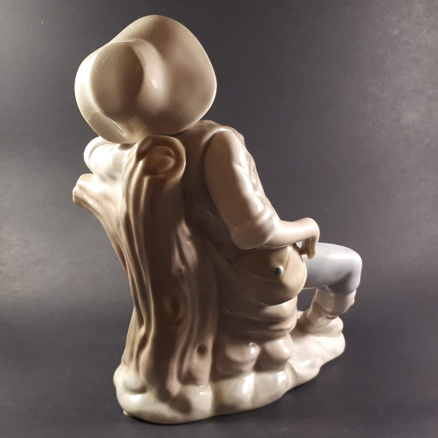 Tengra Spanish figurine boy sitting on beautiful shiny porcelain tree trunk