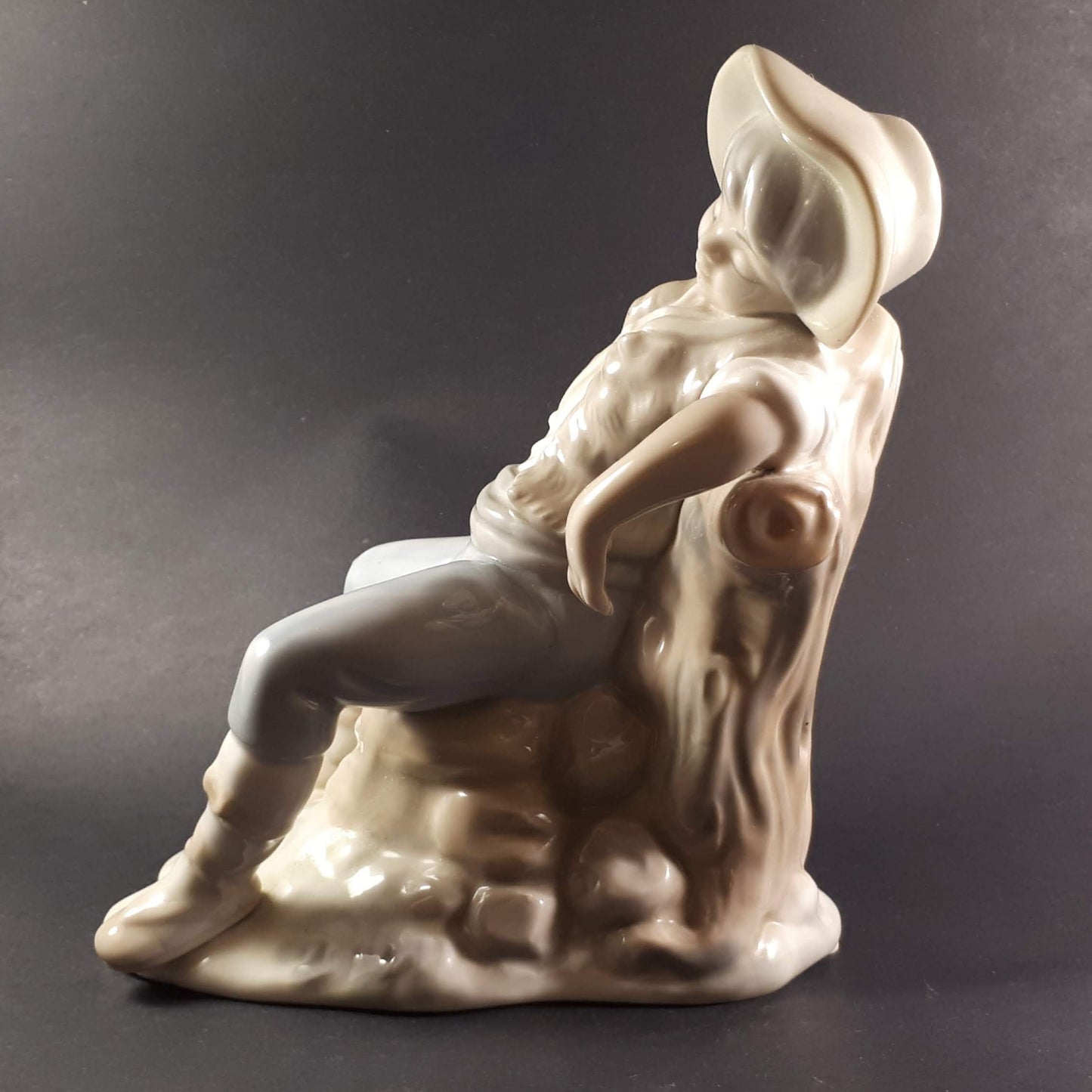 Tengra Spanish figurine boy sitting on beautiful shiny porcelain tree trunk