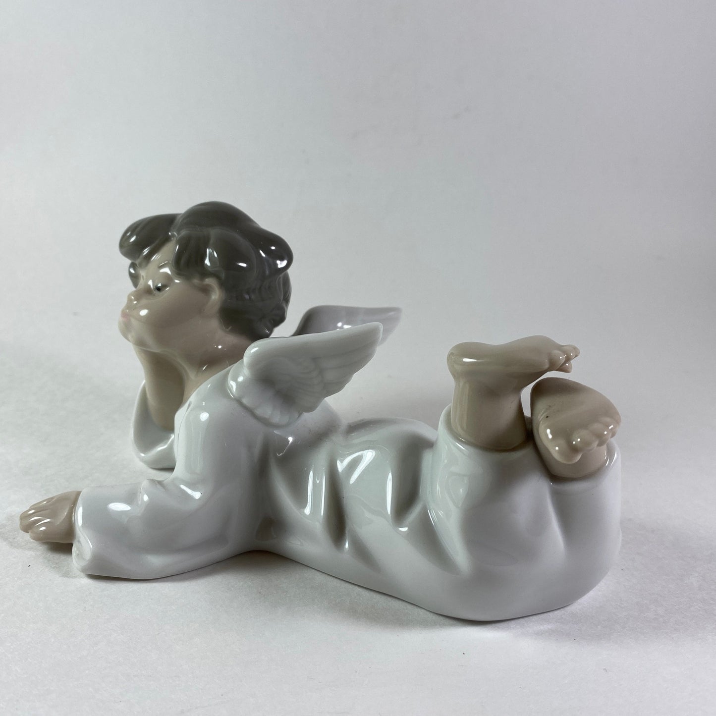 Lladro angel figurine in glossy porcelain lying down with legs crossed 4541