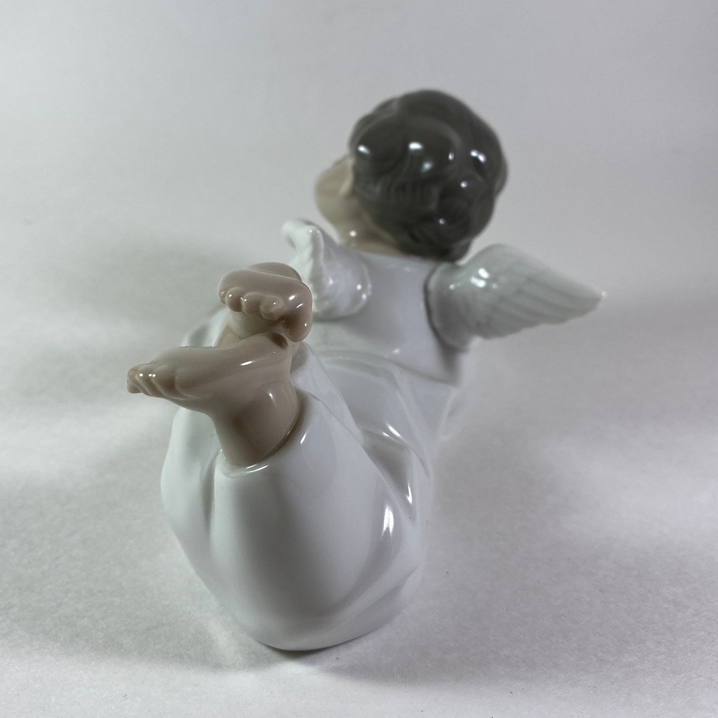 Lladro angel figurine in glossy porcelain lying down with legs crossed 4541