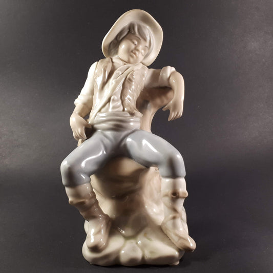 Tengra Spanish figurine boy sitting on beautiful shiny porcelain tree trunk